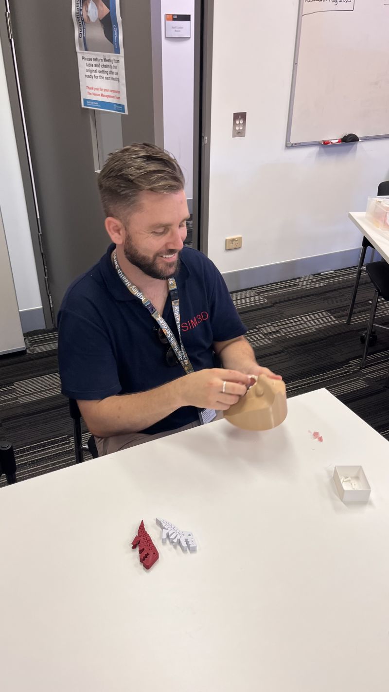 Photo of Zachary Buxton, the founder of SIM3D, working on constructing a 3D-printed dental training model.