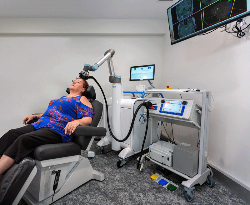 Photo of a woman undertaking treatment with a TNS machine